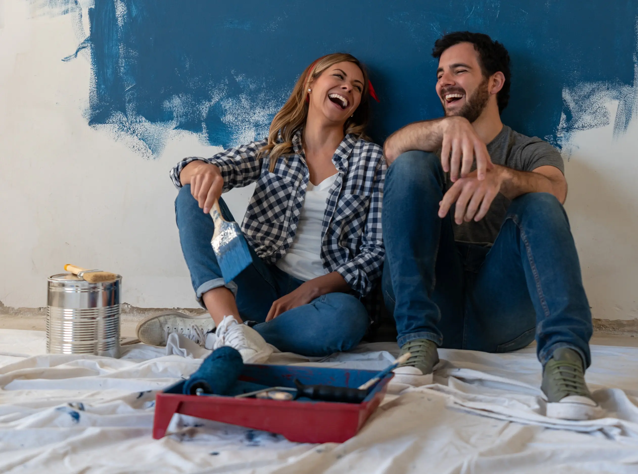 happy couple painting a room
